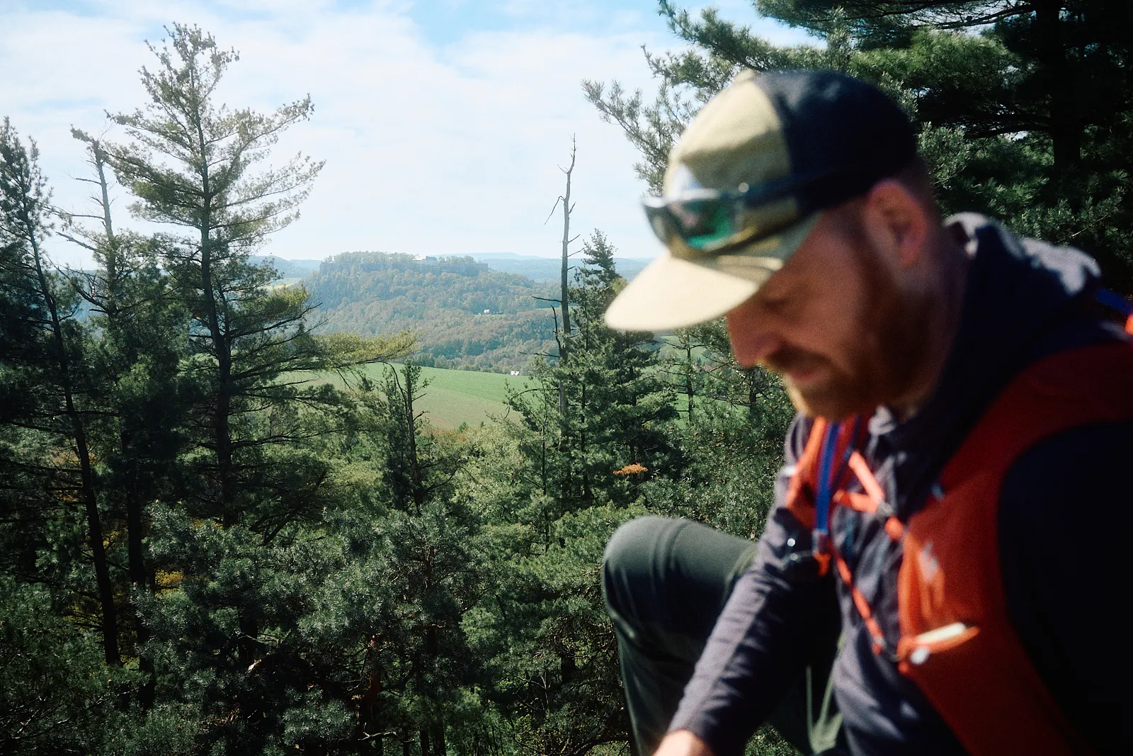 Michael Rusch unterwegs auf dem Wanderweg, mit Cap und Rucksack, Blick über das Elbsandsteingebirge