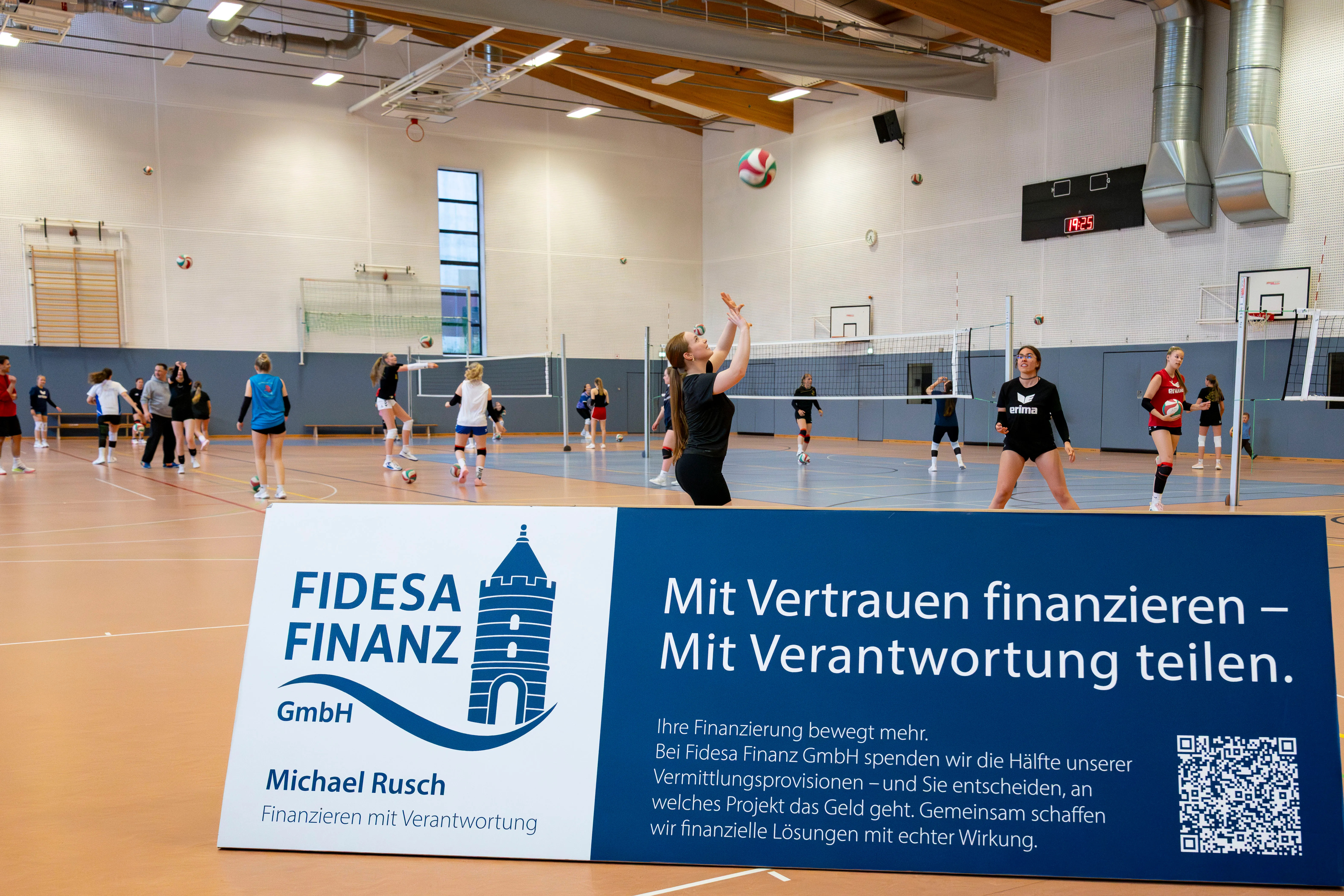 Trainingsszene in der Volleyball-Halle des VC Blau-Weiß Brandenburg mit Fidesa-Banner am Spielfeldrand.